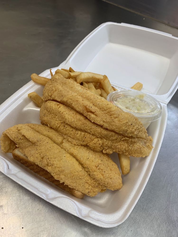 Golden fried fish fillets served with fries, lemon and coleslaw