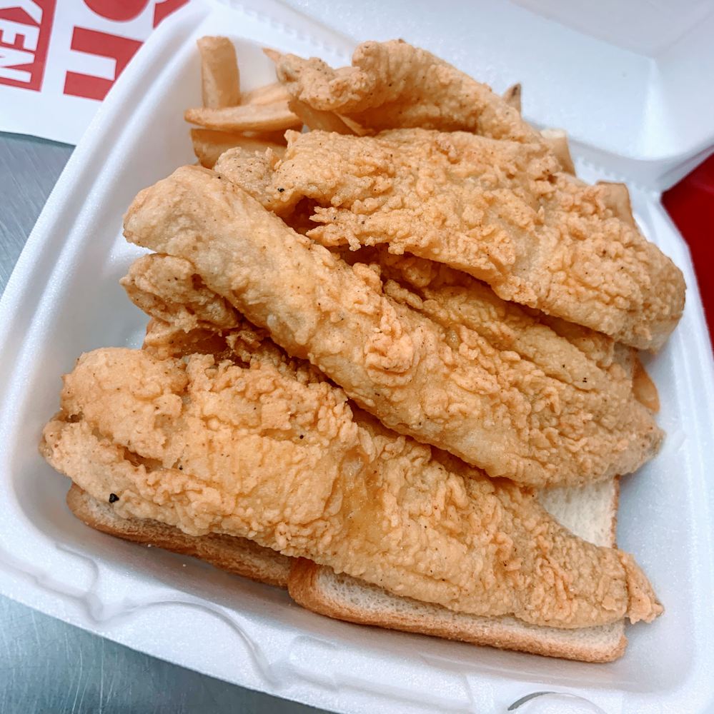 A takeout box piled with golden, crispy fried pieces